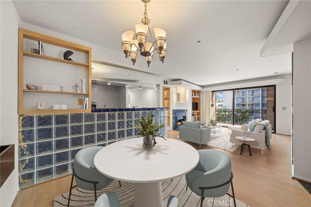 35 Linden Unit 302, Long Beach, CA 90802 - dining area featuring a chandelier, wood finished floors, and a warm lit fireplace