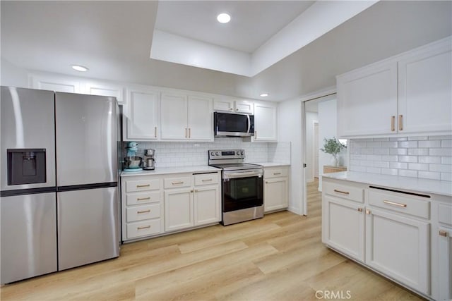 4210 Sirius Ave, Lompoc, CA 93436 - kitchen featuring light wood-style flooring, white cabinets, light countertops, stainless steel appliances, and backsplash