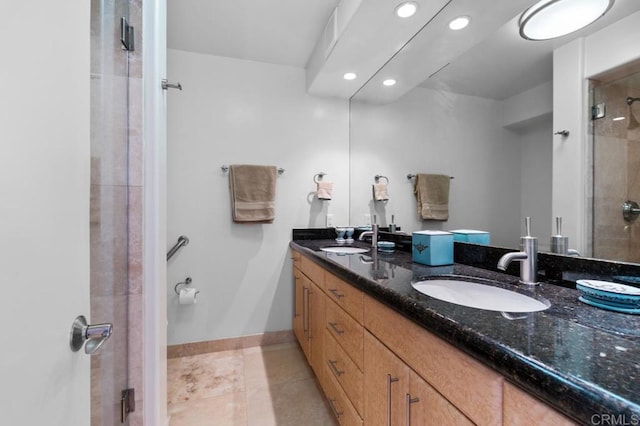 full bathroom featuring double vanity, a shower stall, tile patterned flooring, and a sink