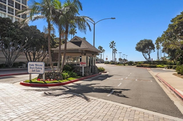 view of road with curbs, street lighting, traffic signs, and sidewalks