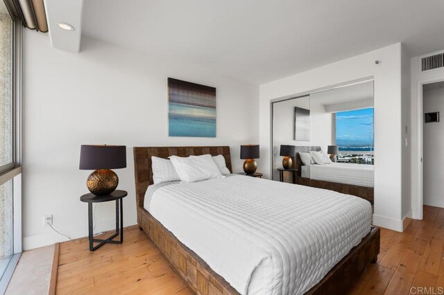 bedroom featuring light wood-style flooring, visible vents, recessed lighting, and multiple windows