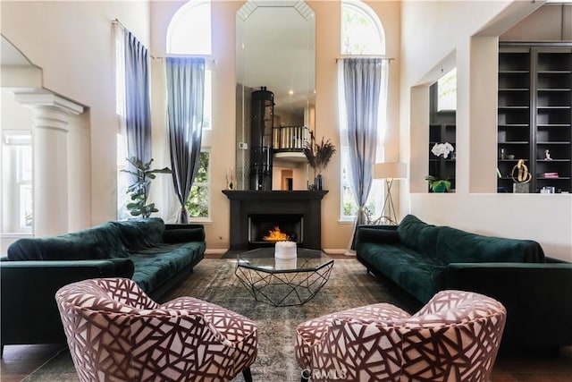 26962 Willow Tree Ln, Laguna Hills, CA 92653 - living room with baseboards, a towering ceiling, and a warm lit fireplace