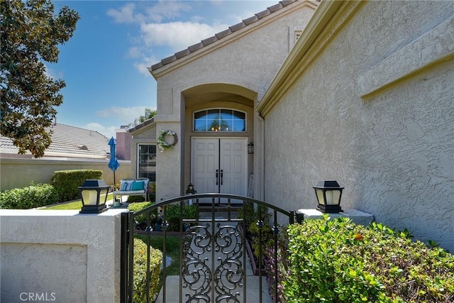 23898 Via Pamilla, Murrieta, CA 92562 - doorway to property featuring stucco siding, fence, and a gate