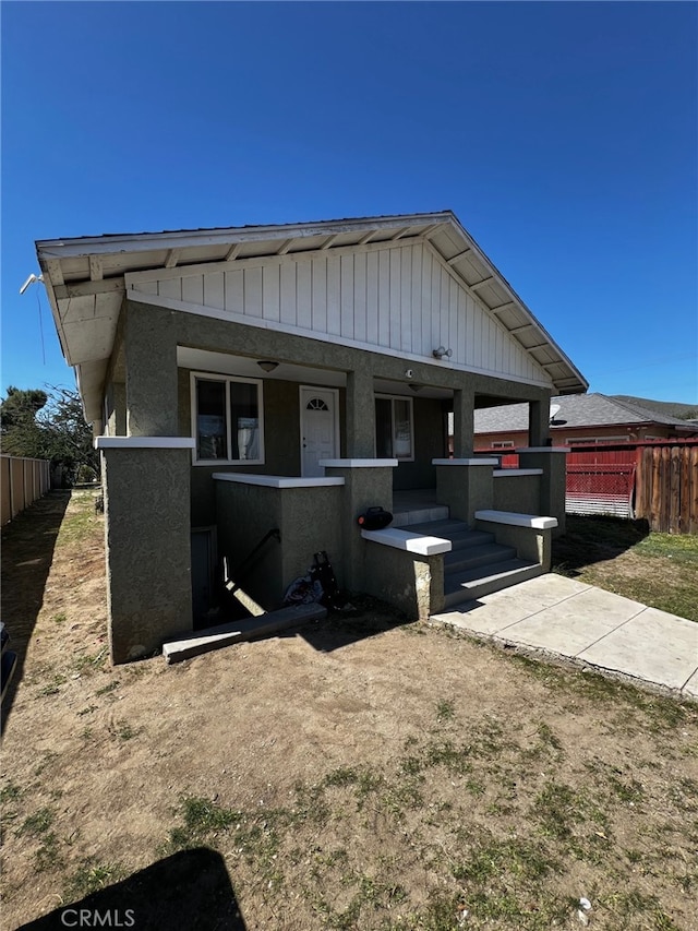 view of front of property featuring a porch and fence