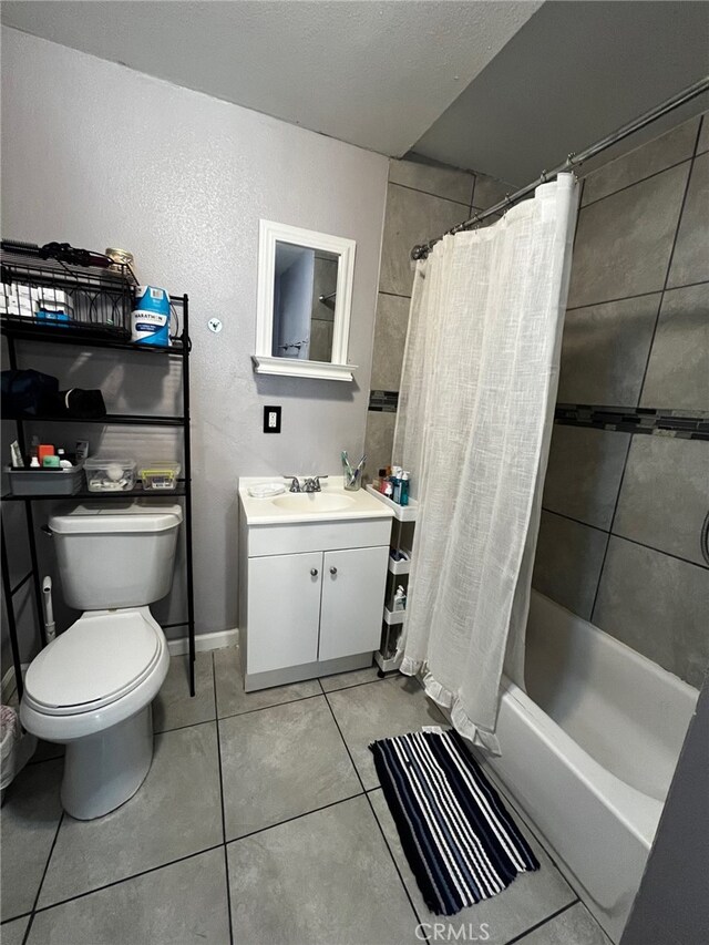 bathroom with baseboards, toilet, shower / bath combo with shower curtain, vanity, and tile patterned flooring