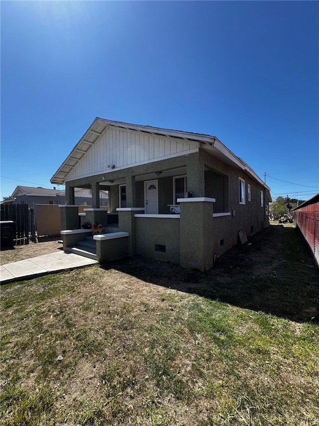 rear view of house with a yard, crawl space, and fence