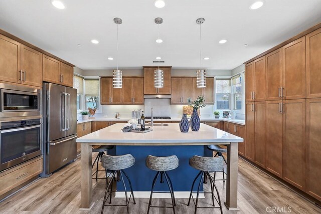 7 Alienta Ln, Rancho Mission Viejo, CA 92694 - kitchen featuring brown cabinets, stainless steel appliances, light countertops, and a breakfast bar area