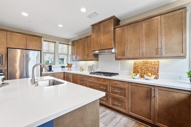 7 Alienta Ln, Rancho Mission Viejo, CA 92694 - kitchen with visible vents, under cabinet range hood, brown cabinets, a sink, and appliances with stainless steel finishes