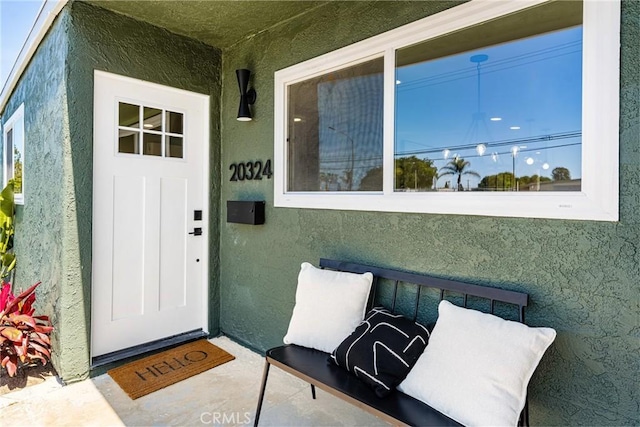 view of exterior entry with stucco siding