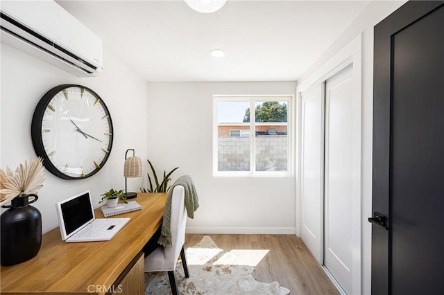 home office with a wall mounted AC, baseboards, and wood finished floors