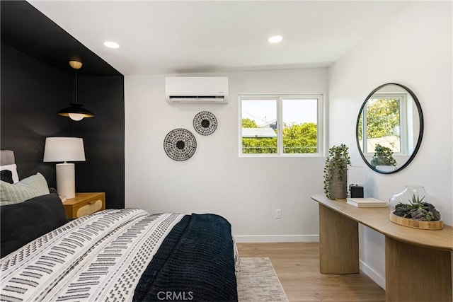 bedroom featuring recessed lighting, light wood-type flooring, an AC wall unit, and baseboards