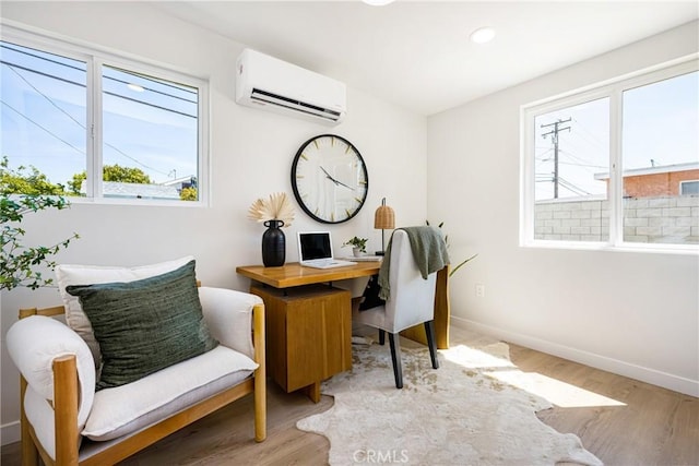 office featuring recessed lighting, light wood-style floors, an AC wall unit, and baseboards