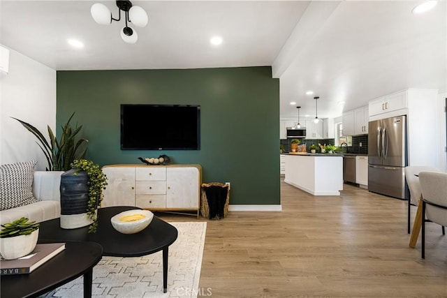 living area with recessed lighting, light wood-style flooring, and baseboards