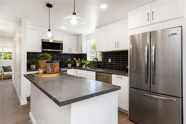 kitchen featuring dark countertops, white cabinetry, a sink, and appliances with stainless steel finishes