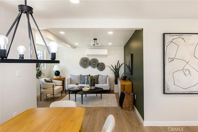living area with wood finished floors, baseboards, an AC wall unit, and recessed lighting