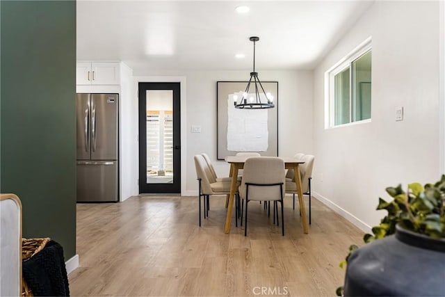 dining area with recessed lighting, light wood finished floors, baseboards, and an inviting chandelier