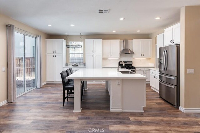 32460 Perigord Rd, Winchester, CA 92596 - kitchen with stainless steel appliances, wall chimney exhaust hood, white cabinets, recessed lighting, and dark wood-style floors