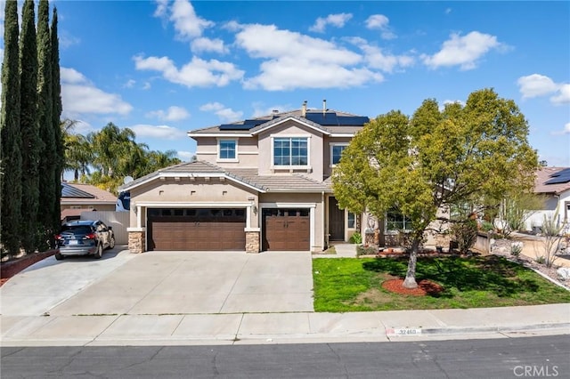 32460 Perigord Rd, Winchester, CA 92596 - view of front facade featuring stucco siding, roof mounted solar panels, a front lawn, driveway, and stone siding