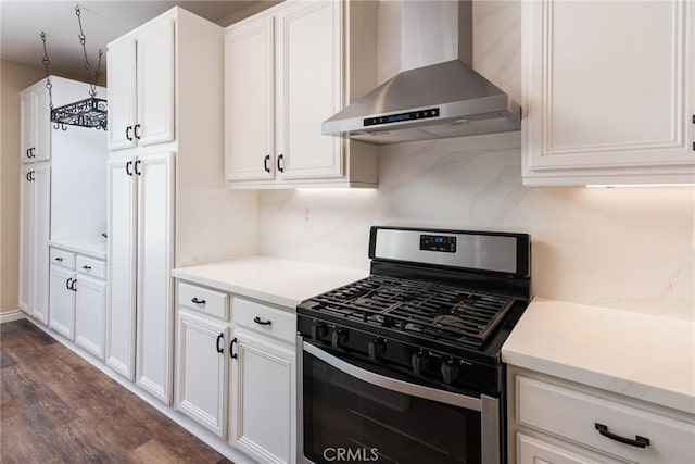 32460 Perigord Rd, Winchester, CA 92596 - kitchen with wall chimney exhaust hood, stainless steel gas stove, dark wood finished floors, white cabinetry, and tasteful backsplash
