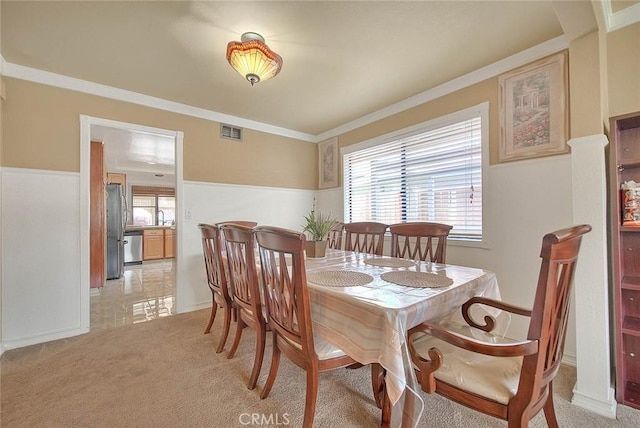 dining space featuring light carpet, baseboards, ornamental molding, and visible vents