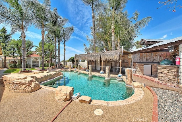 view of swimming pool featuring a gazebo, exterior kitchen, a fenced in pool, and a patio