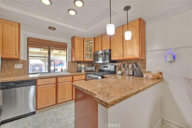 kitchen featuring a peninsula, glass insert cabinets, backsplash, stainless steel appliances, and a sink