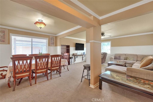 dining space with crown molding, baseboards, a ceiling fan, and light colored carpet