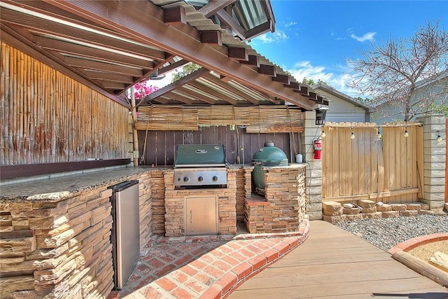 view of patio / terrace featuring area for grilling, an outdoor kitchen, a pergola, and fence