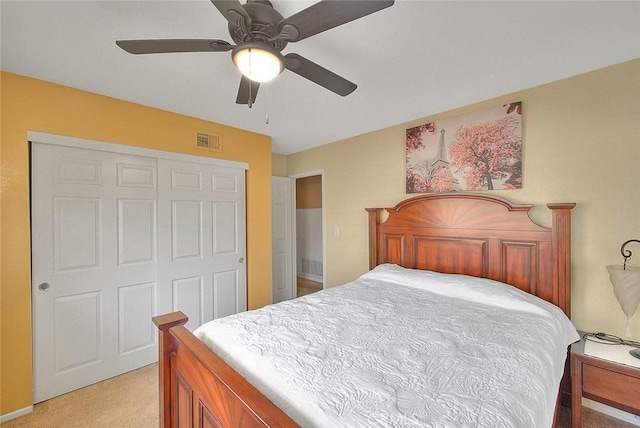 bedroom featuring visible vents, ceiling fan, a closet, and light colored carpet