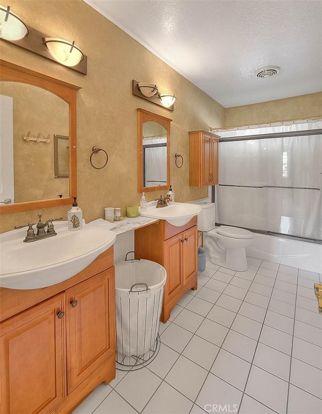 full bath featuring a textured wall, a sink, tile patterned flooring, and visible vents