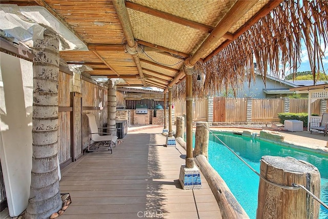 view of swimming pool with grilling area and a fenced in pool