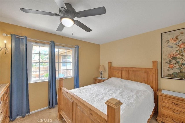 bedroom with light colored carpet, baseboards, and ceiling fan