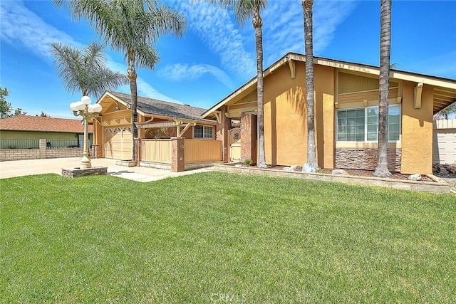 view of front facade featuring stucco siding, driveway, an attached garage, a front lawn, and fence