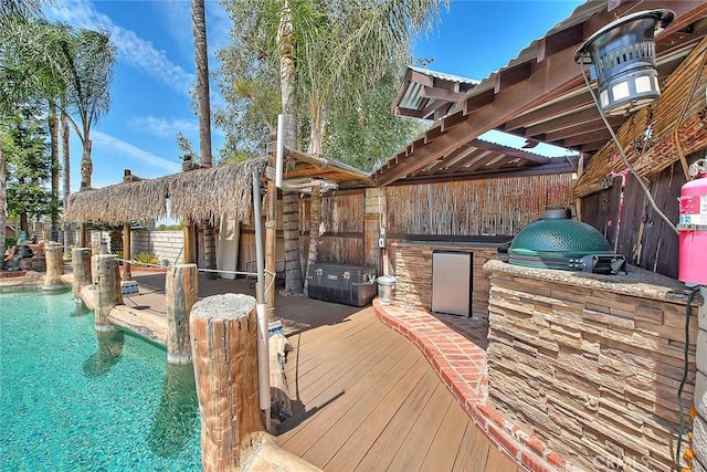 exterior space with a fenced in pool, a wooden deck, fence, and area for grilling