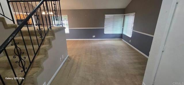 interior space with lofted ceiling, carpet, and baseboards