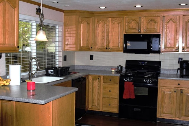 kitchen with black appliances, backsplash, brown cabinetry, and a sink