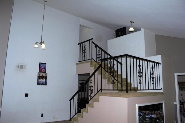 stairway featuring a chandelier and a high ceiling