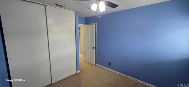 unfurnished bedroom featuring carpet flooring, visible vents, ceiling fan, baseboards, and a closet
