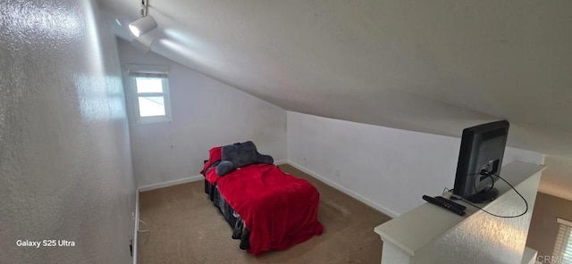 bedroom featuring baseboards, carpet floors, and lofted ceiling