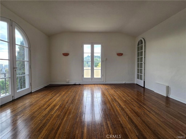 spare room with lofted ceiling, french doors, dark wood-style floors, and baseboards
