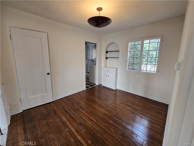 empty room with baseboards and dark wood-style floors