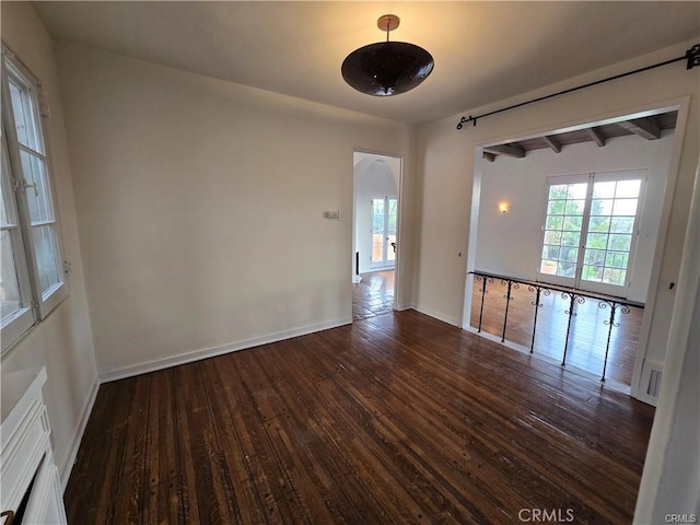 spare room with wood-type flooring and baseboards