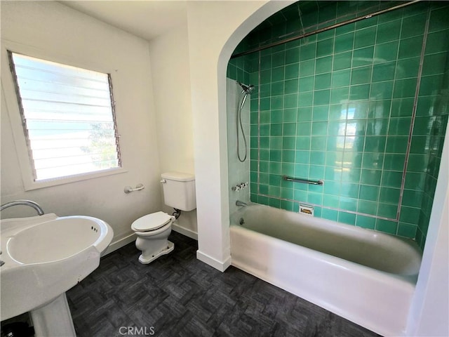 full bath featuring toilet, baseboards, and  shower combination