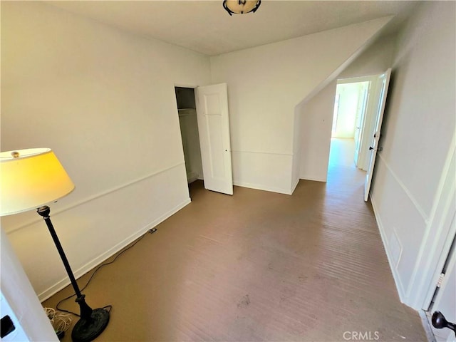 interior space with wood finished floors, a closet, and baseboards