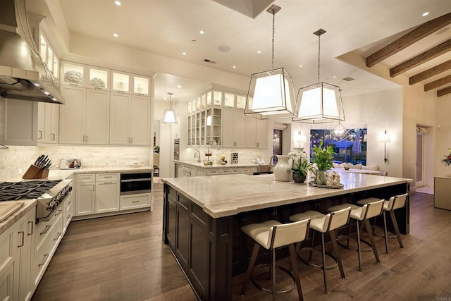 18320 Colina Fuerte, Rancho Santa Fe, CA 92067 - kitchen with ventilation hood, stainless steel gas cooktop, decorative backsplash, a spacious island, and white cabinetry