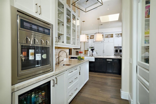 18320 Colina Fuerte, Rancho Santa Fe, CA 92067 - bar area with a sink, a skylight, beverage cooler, exhaust hood, and stainless steel oven