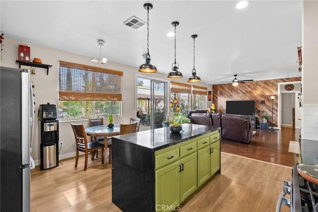 13126 Glandt Ct, Corona, CA 92883 - kitchen featuring green cabinets, wooden walls, freestanding refrigerator, visible vents, and ceiling fan