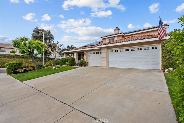 13126 Glandt Ct, Corona, CA 92883 - mediterranean / spanish house with concrete driveway, a chimney, a garage, a tiled roof, and roof mounted solar panels