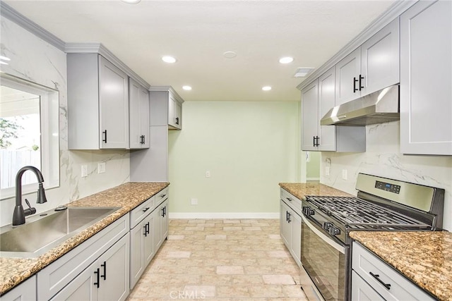 kitchen with stainless steel range with gas stovetop, baseboards, a sink, under cabinet range hood, and recessed lighting