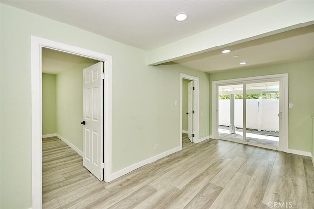 empty room with baseboards, light wood-type flooring, and recessed lighting